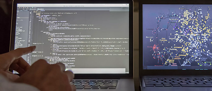 Two laptops and hands typing